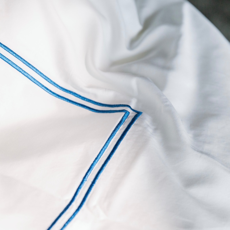 Weiße Bettwäsche mit zwei blauen Streifen in 5-Sterne-Hotelqualität