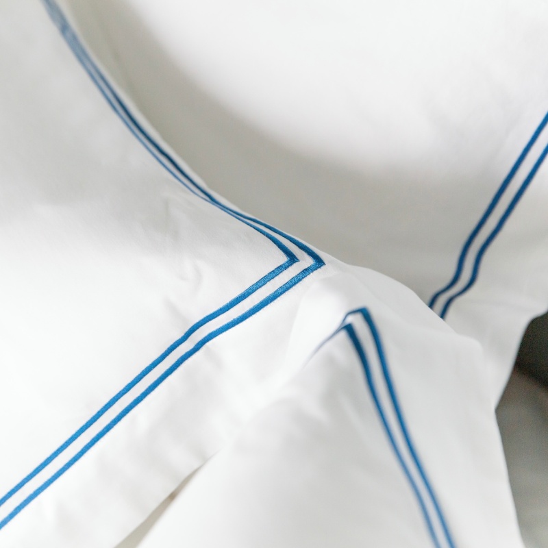 Weiße Bettwäsche mit zwei blauen Streifen in 5-Sterne-Hotelqualität